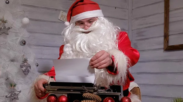Papai Noel escrevendo resposta a uma carta em uma máquina de escrever — Fotografia de Stock