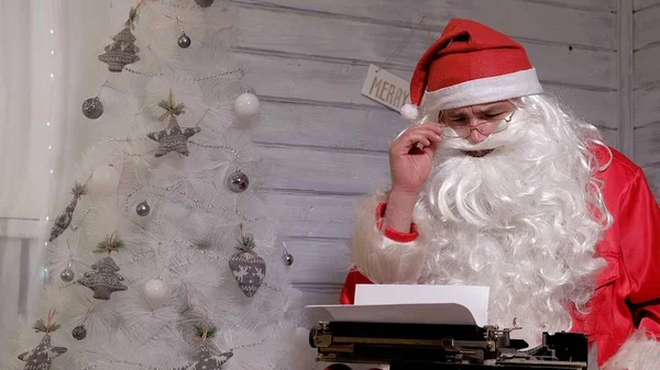Papai Noel escrevendo resposta a uma carta em uma máquina de escrever — Fotografia de Stock
