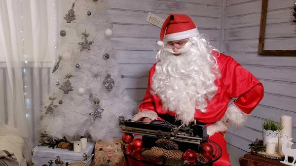 Santa Claus writing reply to a letter on a typewriter — Stock Photo, Image