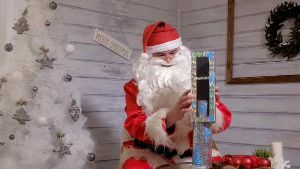 Santa toont truc met een pijp — Stockfoto