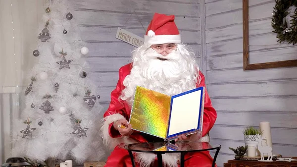 Santa toont focus met een magische boek — Stockfoto