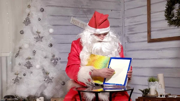 Santa muestra el enfoque con un libro de magia —  Fotos de Stock