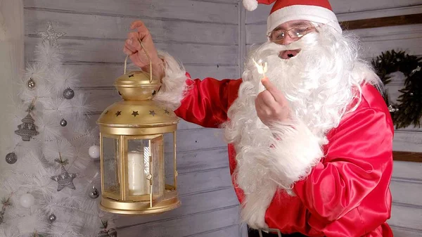 Санта держит золотой рождественский фонарь — стоковое фото