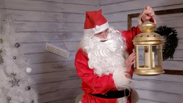 Papai Noel está segurando uma lanterna dourada de Natal — Fotografia de Stock