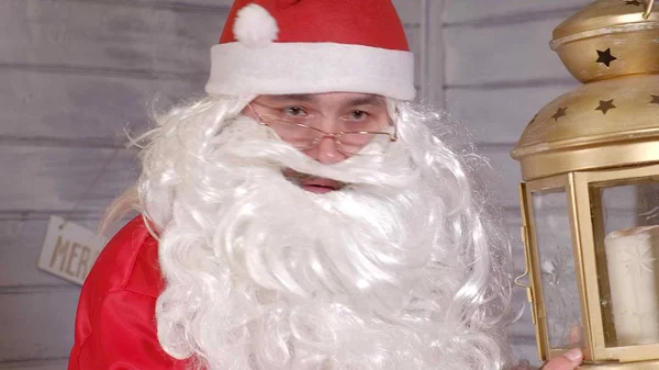 Santa is holding a Christmas golden lantern — Stock Photo, Image