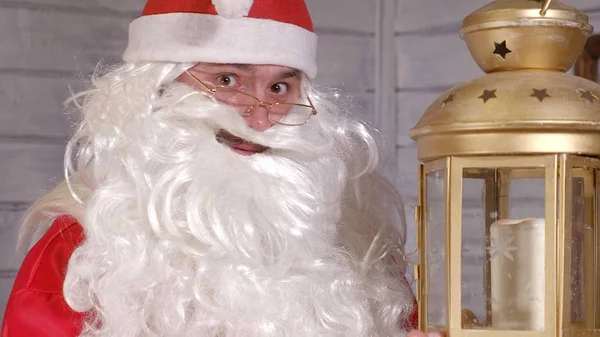 Santa houdt een kerst gouden lantaarn — Stockfoto