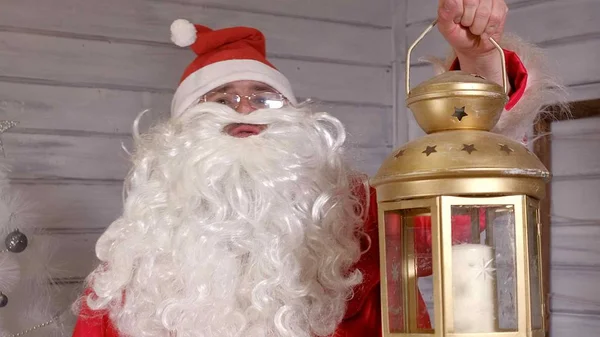 Santa is holding a Christmas golden lantern — Stock Photo, Image