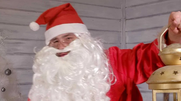 Santa je drží Lucerna vánoční zlatý — Stock fotografie