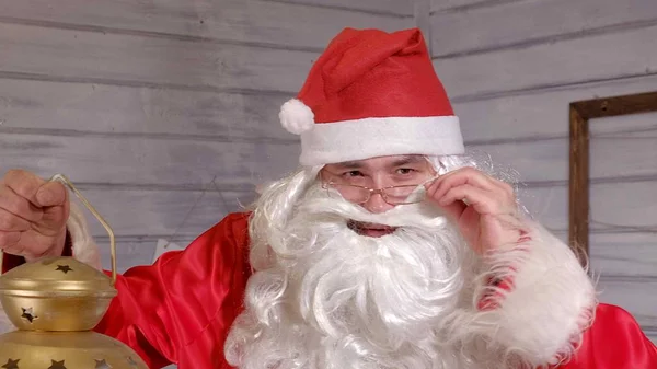 Santa is holding a Christmas golden lantern — Stock Photo, Image