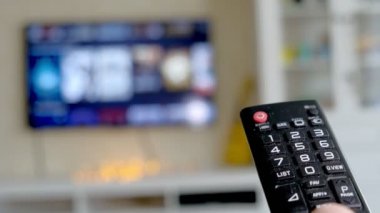 Elini tut Tv uzaktan kumanda. TV arka planda.