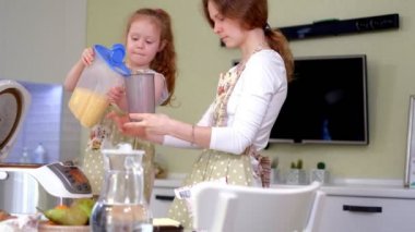Genç mutlu anne ve onun sevimli kıvırcık yürümeye başlayan çocuk daughterr bir mutfak pişirmek