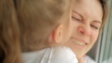 Cam kenarında oturan kızı annesiyle yakın çekim portre.