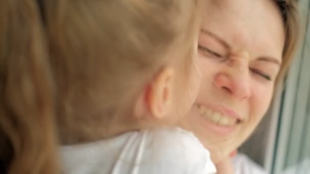 Gros plan portrait de la mère avec sa fille assise près de la fenêtre . — Video