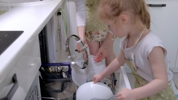 A rapariga ajuda a minha mãe a tirar os pratos da máquina de lavar louça. — Vídeo de Stock
