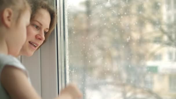 Close-up portret van moeder met dochter zitten bij het raam. — Stockvideo