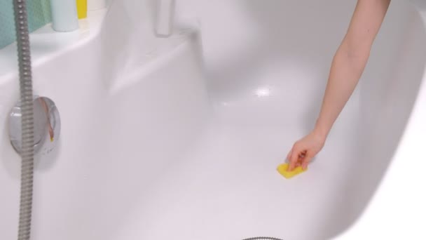 A woman cleaning bath at home. Female washing bathtub and faucet — Stock Video