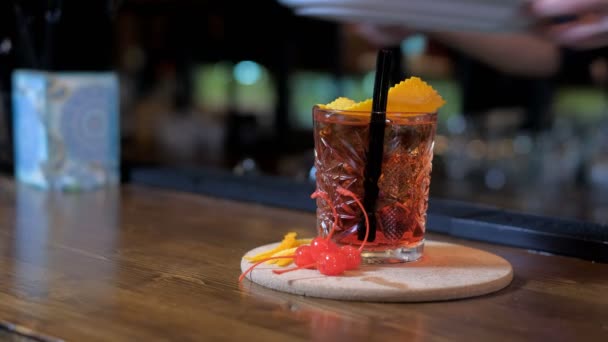 Коктейльное стекло на деревянном столе в баре — стоковое видео