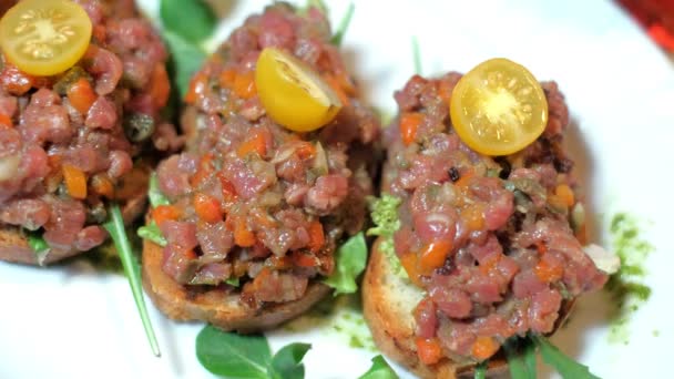 Bruschetta, on slices of toasted baguette garnished with basil — Stock Video
