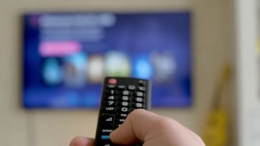 Elini tut Tv uzaktan kumanda. TV arka planda.