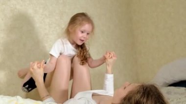 güzel anne ve kızı kucaklama ve evde yatakta yatak odasında oyun