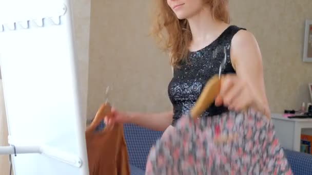 Женщина примеряет новую одежду перед зеркалом дома — стоковое видео