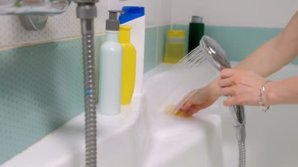 A woman cleaning bath at home. Female washing bathtub and faucet — Stock Video