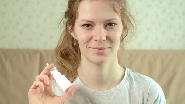 The woman hurts her nose because she has cold. sprinkles drops in the nose — Stock Video