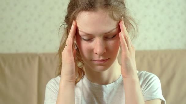 Frau mit Kopfschmerzen hält ihre Hand an den Kopf — Stockvideo