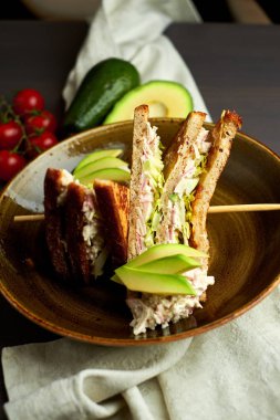 Tahta arka planda marul, jambon, peynir ve domatesli sağlıklı sandviç tostu.