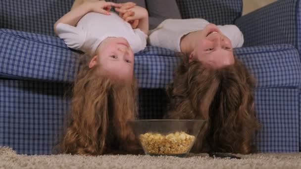 Glückliche liebende Familie. Mutter und Tochter essen Popcorn auf dem Bett im Zimmer. vor dem Fernseher — Stockvideo