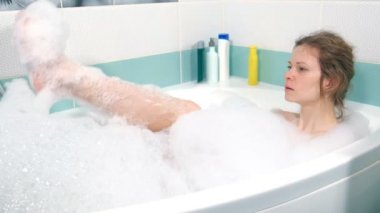 Banyoda güzel kadın rahatlatıcı. Beyaz köpük, acelesiz yıkama