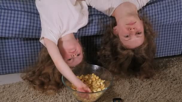 Glückliche liebende Familie. Mutter und Tochter essen Popcorn auf dem Bett im Zimmer. vor dem Fernseher — Stockvideo