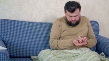 İçme suyu yatakta oturmuş haplarla adamdır.