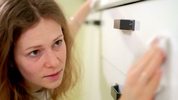 Jovem mulher limpeza com espanador na cozinha em casa — Vídeo de Stock