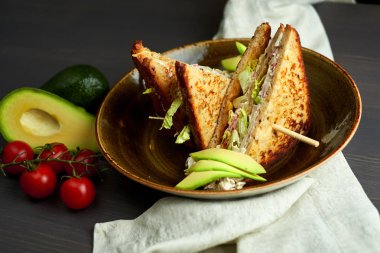 Tahta arka planda marul, jambon, peynir ve domatesli sağlıklı sandviç tostu.