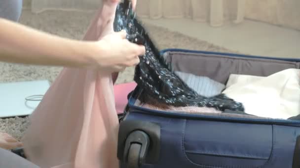 Mulher recolhe uma mala em um quarto de casa . — Vídeo de Stock