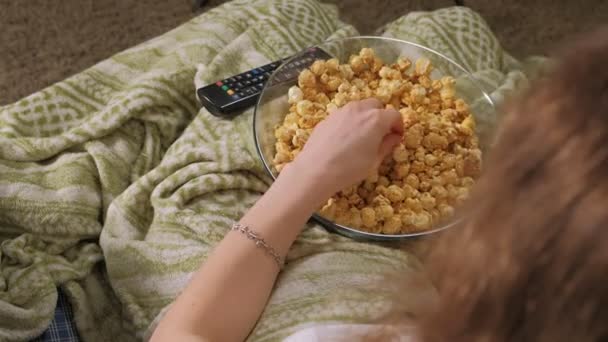 Szczęśliwy, kochającą rodzinę. Matka i jej córka dziecko dziewczynka jedzą popcorn na łóżku w pokoju. przodu telewizora — Wideo stockowe