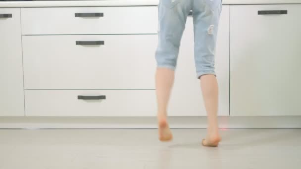 Fröhliche junge lustige Frau tanzt zu Hause in der Küche — Stockvideo