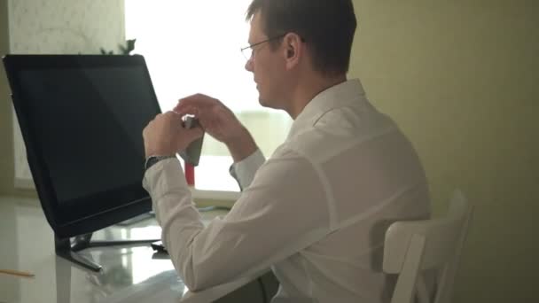 Homme nerveux en chemise blanche buvant de l'alcool, travaillant à l'ordinateur au bureau à domicile, stress — Video