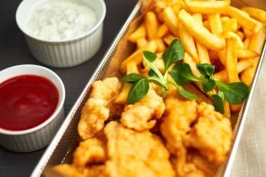 tavuk nuggets kızartması ve ahşap tahta üzerinde farklı sos ile,
