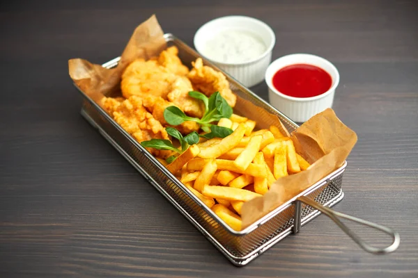 tavuk nuggets kızartması ve ahşap tahta üzerinde farklı sos ile,