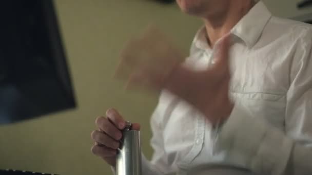 Нервный мужчина в белой рубашке пьет алкоголь, работает за компьютером в домашнем офисе, стресс — стоковое видео