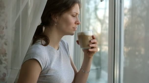 Chica joven con pecas beber capuchino y comer un pastel — Vídeos de Stock