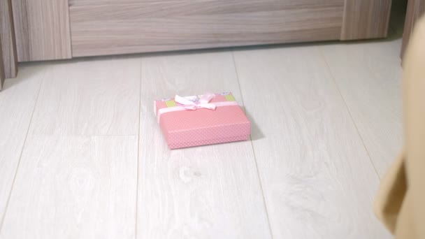 Kvinna finner en gåva under dörren — Stockvideo