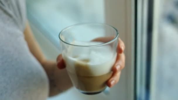 Jeune fille avec des taches de rousseur boire cappuccino et manger un gâteau gros plan — Video