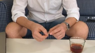 bir adam sağ elini şişeye alkolle, sol nişan yüzüğü. düşünüyor, boşanma. yakın çekim