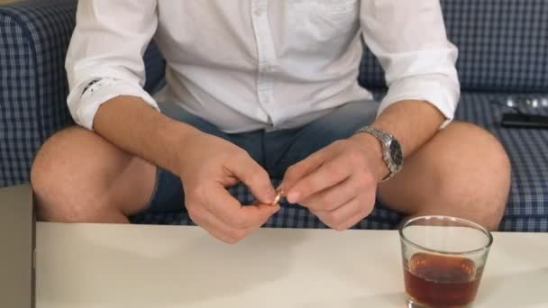 Homme en fiole droite avec alcool, bague de fiançailles gauche. pense, divorce. gros plan — Video