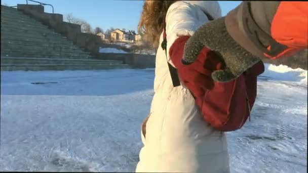 Follow me shot a young woman pull her boyfriend in a beautiful winter city. Girl holding mans hands — Stock Video