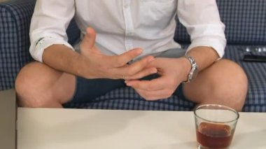 bir adam sağ elini şişeye alkolle, sol nişan yüzüğü. düşünüyor, boşanma. yakın çekim