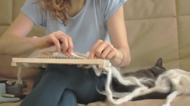 Bir kadın bir tezgah üzerinde güzel bir nakış iplikleri, eve bir stüdyoda yapılan örgüleri, kedi yakındır